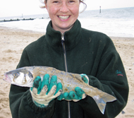 Smiling customer holding freshly caught Sea Bass